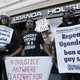 Protesters speak out against gay ban in front of Ugandan police station.
